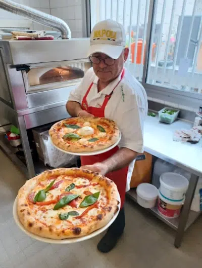 Pizzaiolo servant deux pizzas margherita